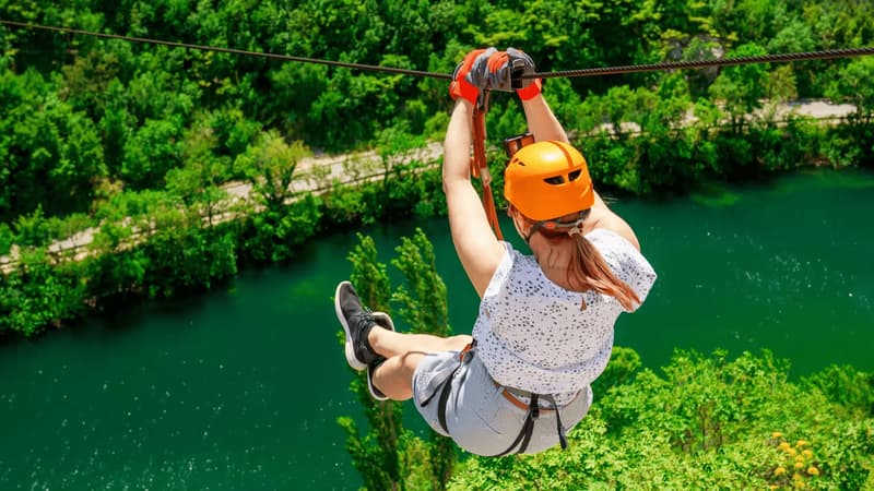 A traveller on a zipline above a river canyon